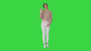 Mutlu genç kadın yeşil ekranda sana el sallıyor, Chroma Key..