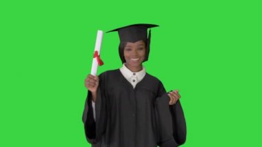 Mezuniyet şapkası ve cübbesiyle yeşil ekranda gülümseyen güzel öğrenci, Chroma Key.