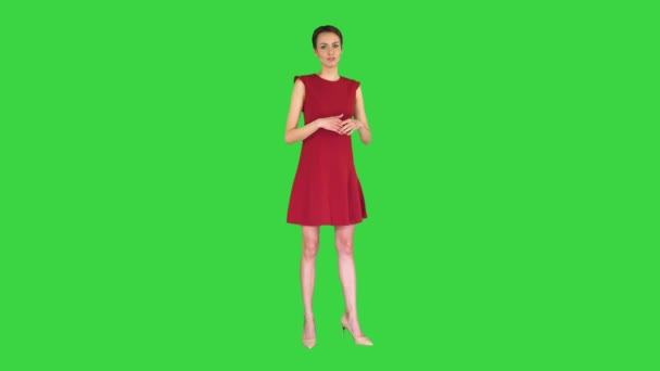緑の画面上の天気予報のようなドレスの話やジェスチャーを作ってきれいな女性,クロマキー. — ストック動画