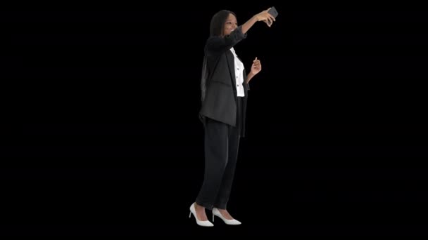 Mulher afroamericana bonita sorrindo em seu telefone disparando uma selfie, Alpha Channel — Vídeo de Stock