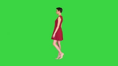 Kırmızı elbiseli bir kız yeşil ekrandaki aynaya bakar gibi dönüyor, Chroma Key..