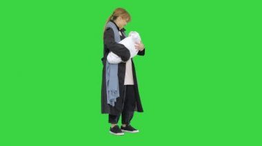 Yeşil Ekran 'da, Chroma Key' de kucağında küçük bir bebeği kucağına alıp yatıştıran genç bir anne..