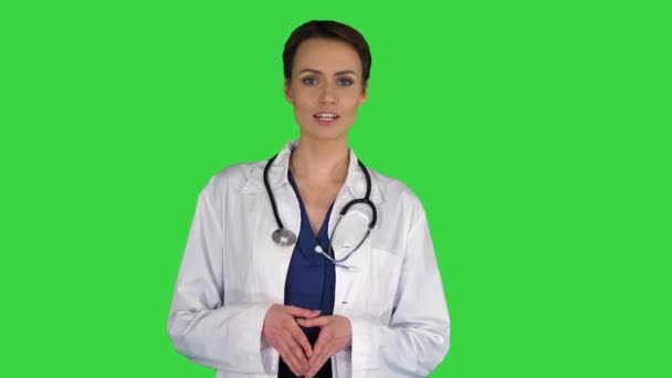 Profesyonel doktor üniformalı, steteskoplu, yeşil ekran Chroma Key 'de kamerayla konuşan genç bir kadın doktor.. — Stok video