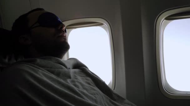 Rest and comfortable flight in the plane. Man in a mask for sleeping. — Stock Video