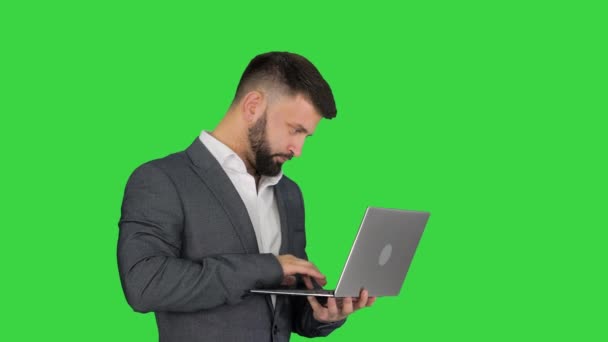 Caucásico hombre escribiendo en el ordenador portátil de pie en una pantalla verde, Chroma Key . — Vídeos de Stock