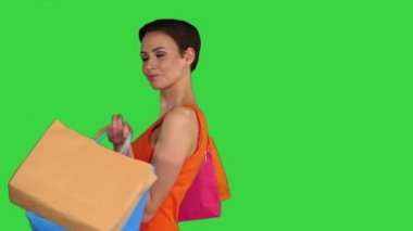 Moda genç bayan alışveriş çantası tutuyor ve yeşil ekranda dönüyor, Chroma Key..