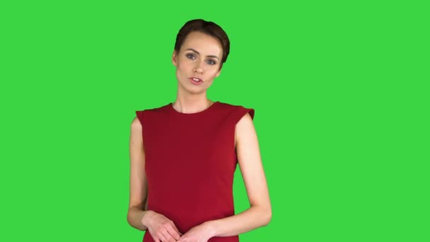 Emocionado hermosa mujer joven en vestido rojo hablando con la cámara en una pantalla verde, Chroma Key . — Vídeos de Stock