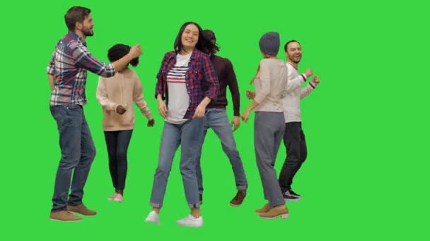 Egy csapat boldog fiatal táncol együtt egy zöld vetítővásznon, Chroma Key.