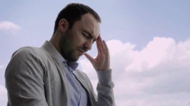 Ruh sağlığı konsepti, genç bunalımlı adamın elini şakağına koyması..