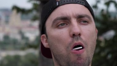 Oturan ve lolipop yiyen adam..