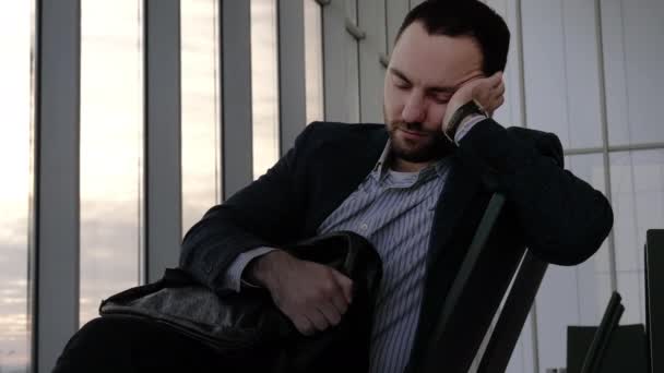 Schöner junger Geschäftsmann mit einem Nickerchen, während er auf den Flug wartet. — Stockvideo