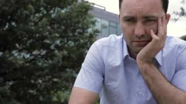 Parkta oturan adam ağır depresyonda ve üzgün..