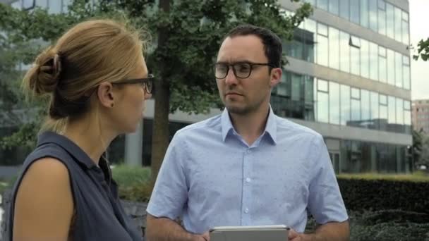 Zakenmensen praten buiten met elektronische tablet. — Stockvideo