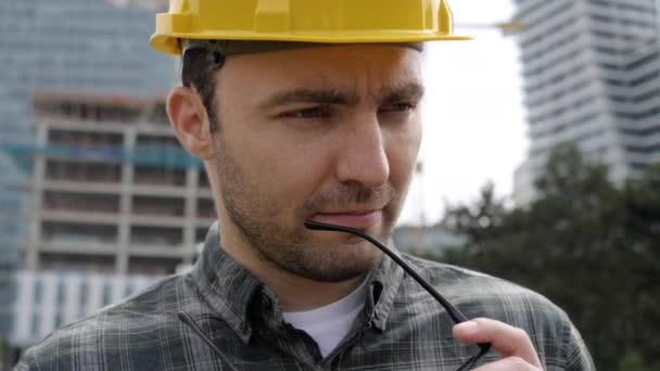 Trabajador de la construcción pensando de pie frente a la obra . — Vídeos de Stock