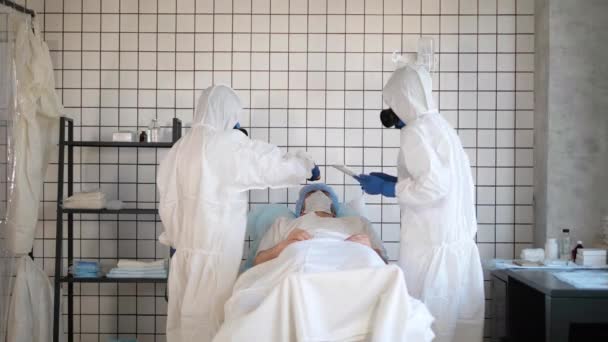 Medico in Hazmat Tuta sterile che misura la temperatura di un paziente in un ospedale . — Video Stock