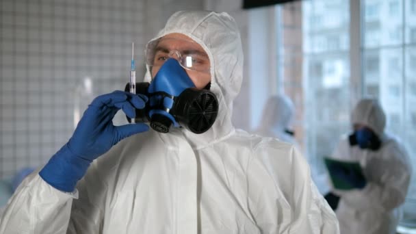 Covid-19 vakcína. Lékař v ochranném oděvu připravuje injekční stříkačku. — Stock video