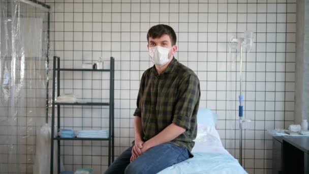 격리 된 남자가 병원 침대에 앉아 카메라로 대화하는 모습. — 비디오