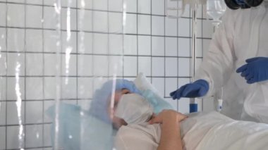 Hasta ameliyattan sonra kendine geldi. Doktor hastanın rahat etmesine yardımcı olur..