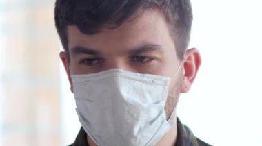 Salgın COVID 19 'dan korkan tıbbi grip maskeli genç bir adam..