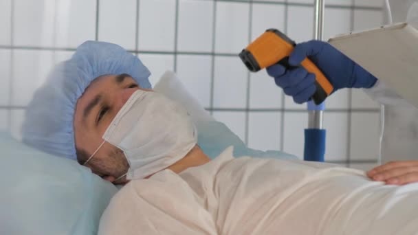 Врач измеряет температуру пациента в больнице . — стоковое видео