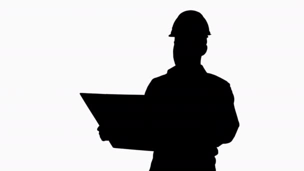 Silhouette Homme ingénieur marchant dans le casque en regardant le projet de reconstruction . — Video