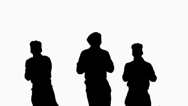 Silhouet Drie jonge lachende koks dansen. — Stockvideo