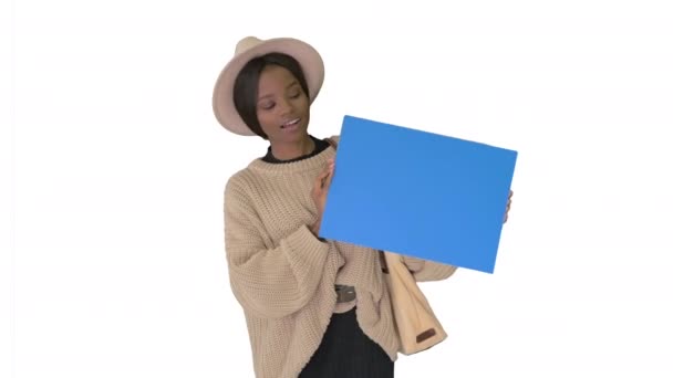 Ελκυστική νεαρή Αφροαμερικανή γυναίκα δείχνει και δείχνει λευκό πίνακα σε λευκό φόντο. — Αρχείο Βίντεο