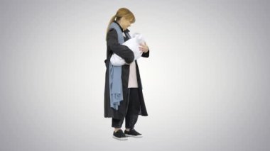Genç anne, küçük bebeği kucağında tutuyor ve sakinleştiriyor..