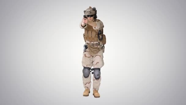Солдат ходить і прицілюється пістолетом на градієнтному фоні . — стокове відео