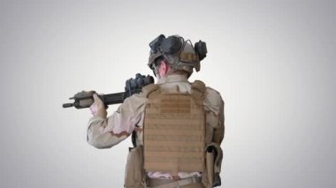 Birleşik Devletler korucusu arka planda saldırı tüfeğiyle yürüyor..