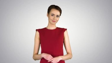 Kırmızı elbiseli model kadın gradyan arkaplanda bir nesnenin üzerinde eli olan bir şey gösteriyor..