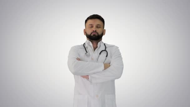 Genç beyaz erkek doktor ellerini katlamış, arka planda duruyor.. — Stok video