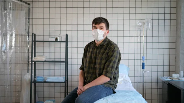 Hombre aislado sentado en una cama en hospita y hablando con la cámara . —  Fotos de Stock