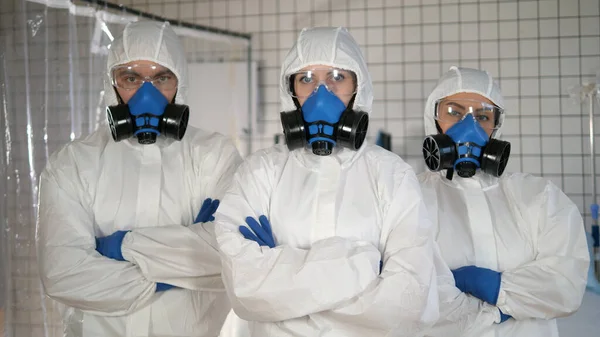 Médecins dans un vêtement de protection debout avec les bras croisés . — Photo