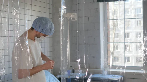 Young man doctor puts the dropper to himself. — Stock Photo, Image