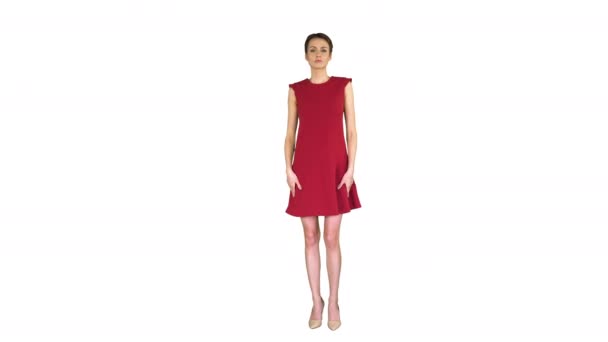 Fille dans une robe rouge, posant, redresse sa robe sur fond blanc .