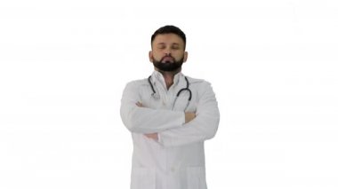 Beyaz arka planda elleri katlanmış genç bir beyaz erkek doktor var..