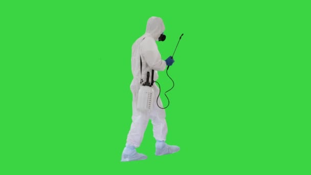 Tehlikeli madde giysisi giyen bilim adamı yeşil ekranda biyolojik tehlike virüsüne karşı yürüyor ve dezenfekte ediyor.. — Stok video