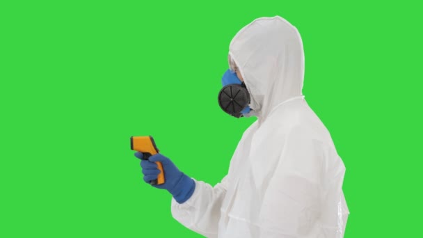 Comprobar la temperatura de un médico corona virus en traje protector con pirómetro en una pantalla verde, Chroma Key . — Vídeos de Stock