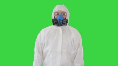 Koruyucu giysiler içindeki erkek doktor yeşil ekran, Chroma Key 'de karantina kuralları sunuyor..