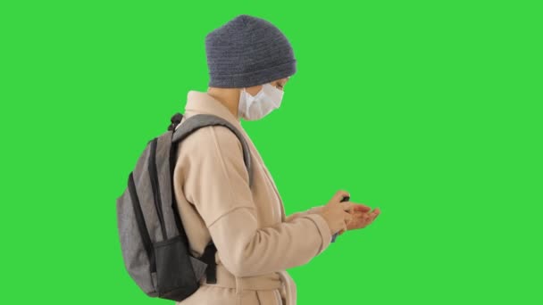 Блондинка в медицинской маске во время карантинного периода с помощью дезинфицирующего средства на зеленом экране, хрома ключ . — стоковое видео