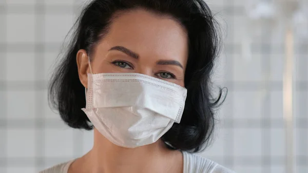 Gelukkig lachende vrouw draagt beschermende medische gezichtsmasker. — Stockfoto
