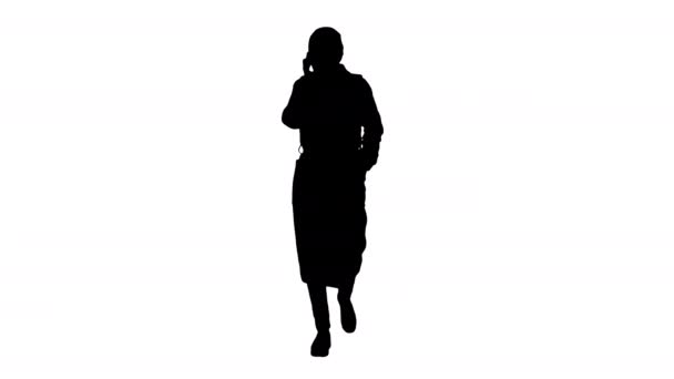 Silhuett Ung kvinna i skyddsmask gå och prata med mobiltelefon. — Stockvideo