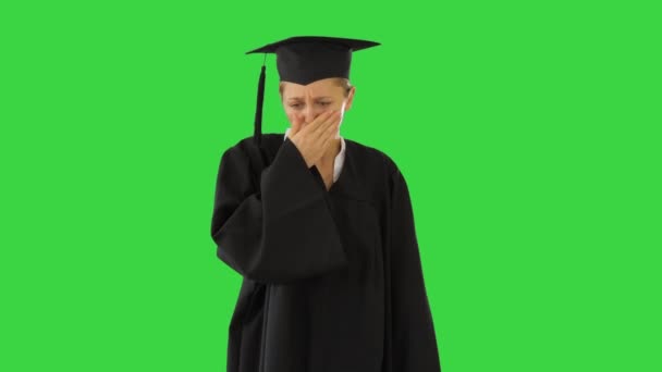 Young graduate girl student in mantle coughing on a Green Screen, Chroma Key. — Stock Video