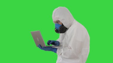 Koruyucu giysili doktor laptopta çalışıyor ve yeşil ekranda iyi sonuçlar alıyor, Chroma Key.