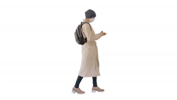 Woman walking in medical mask using sanitizer for her hands Health and safety, N1H1 coronavirus, virus protection care on white background. — Stock Video