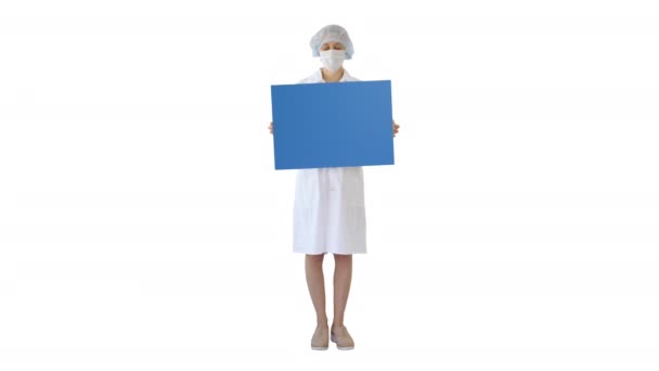 Jeune femme médecin dans un masque tenant un tableau de bord vide sur fond blanc . — Video