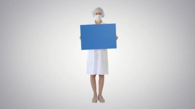 Maskeli genç bayan doktor eğimli arka planda boş bir fatura tahtası tutuyor..