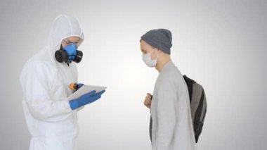 Vücut ısısı yüksek bir kadın koruyucu kıyafetli bir doktor tarafından durduruldu. Arka planda Covid-19 semptomları için yolcuları tarıyordu..