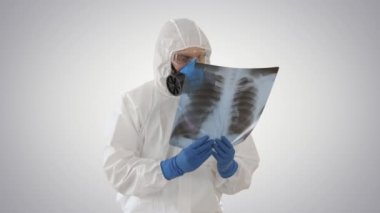 Beyaz Hazmat koruyucu giysi giyen sağlık görevlileri arkaplanda salgın virüsü aramak için röntgen çekiyorlar..